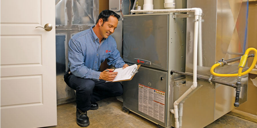 trane service technician checking furnace installation